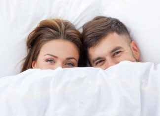 Couple Under Bed Sheets. Guide on How to Have a Better Sex.