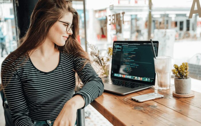 Young woman sitting in front of laptop. Depiction of Mobile Game Development