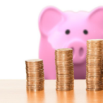 Piggybank with three stacks of coins. Gold Investing Companies representation