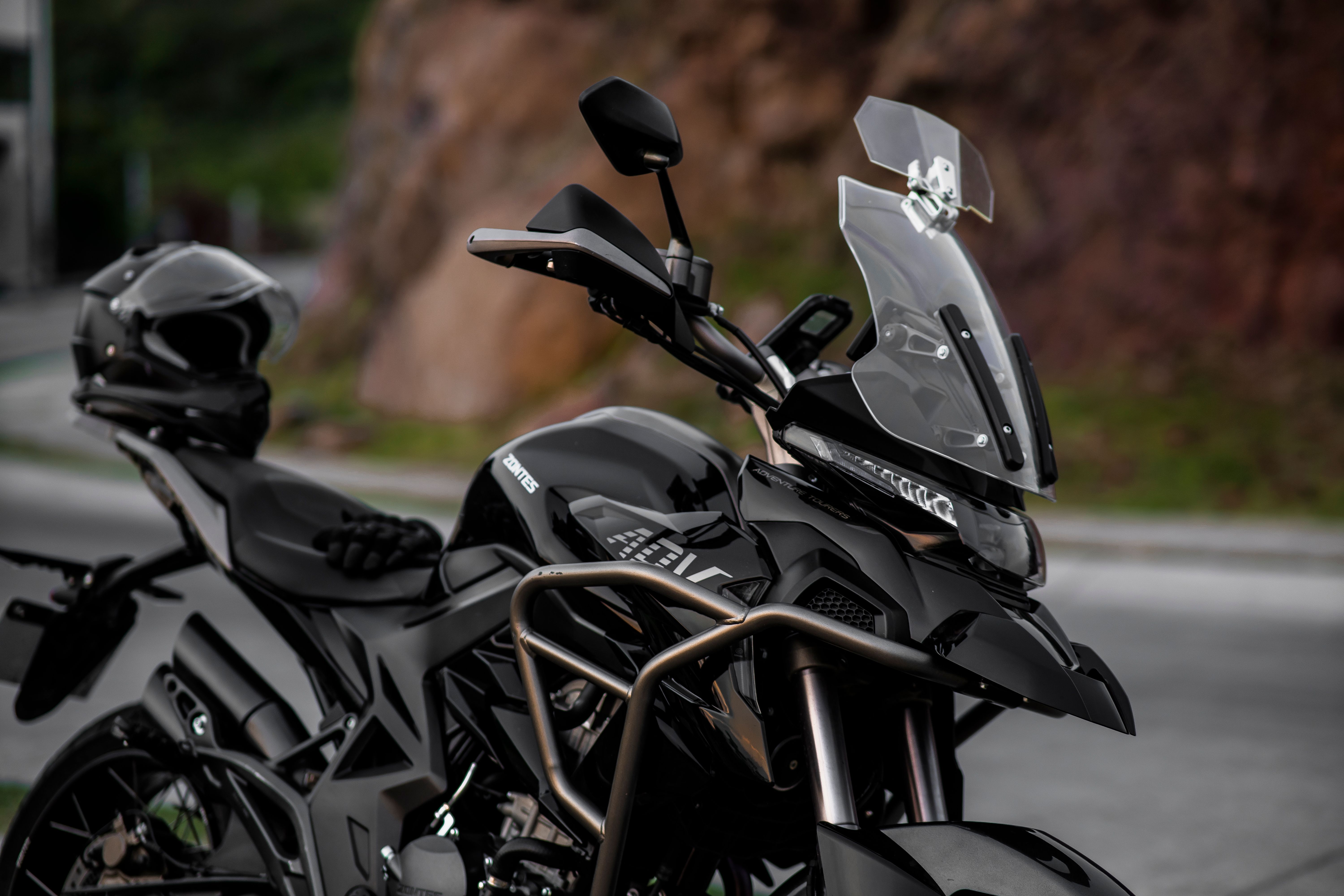 Close-up of a parked black adventure motorcycle with a tall windshield