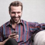 person looking at phone for Online Casino